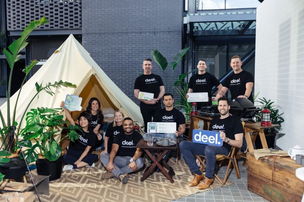 Deel team posing in branded t-shirts at event