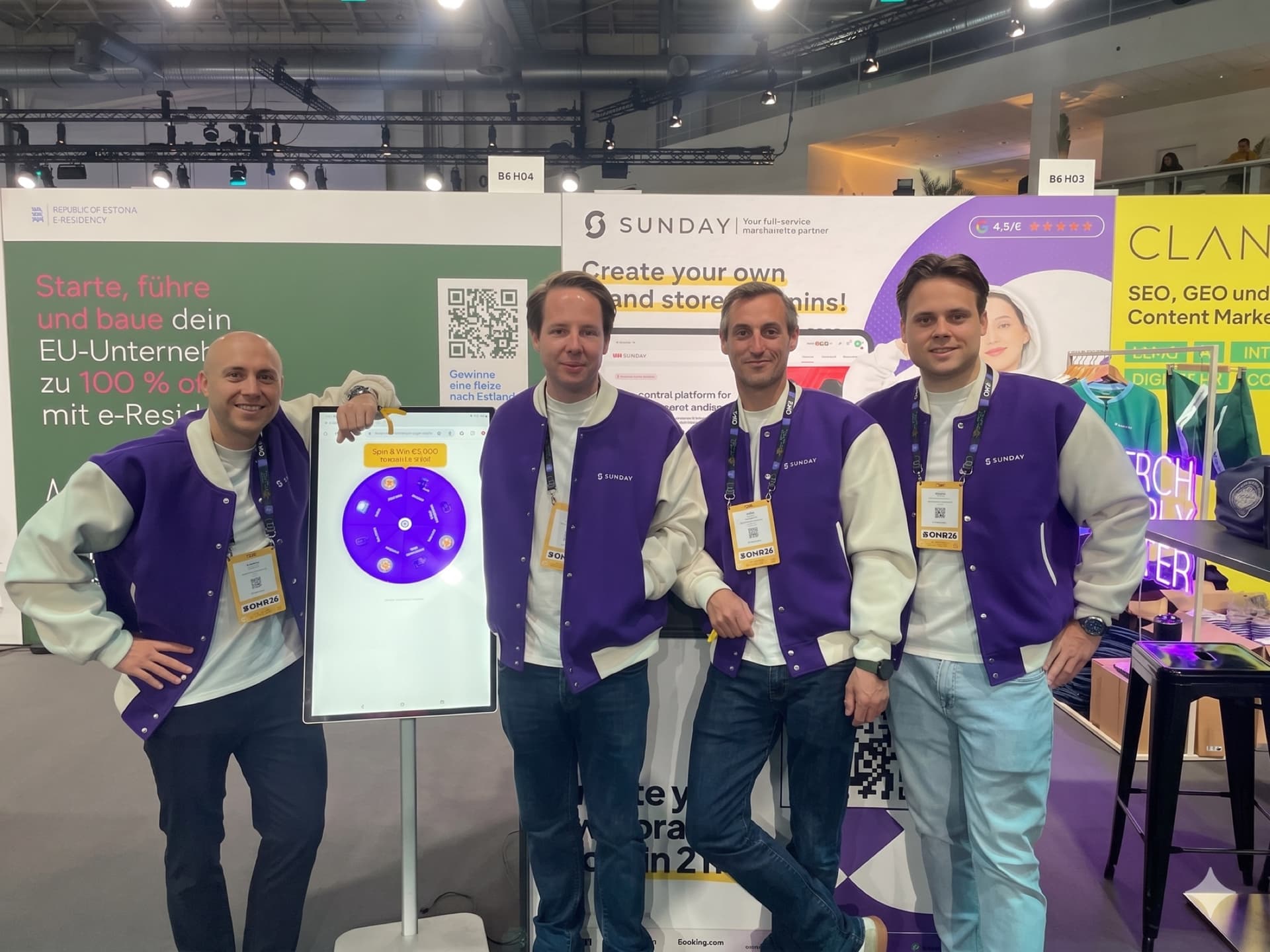 Sunday team in branded purple varsity jackets at the OMR26 trade-show booth
