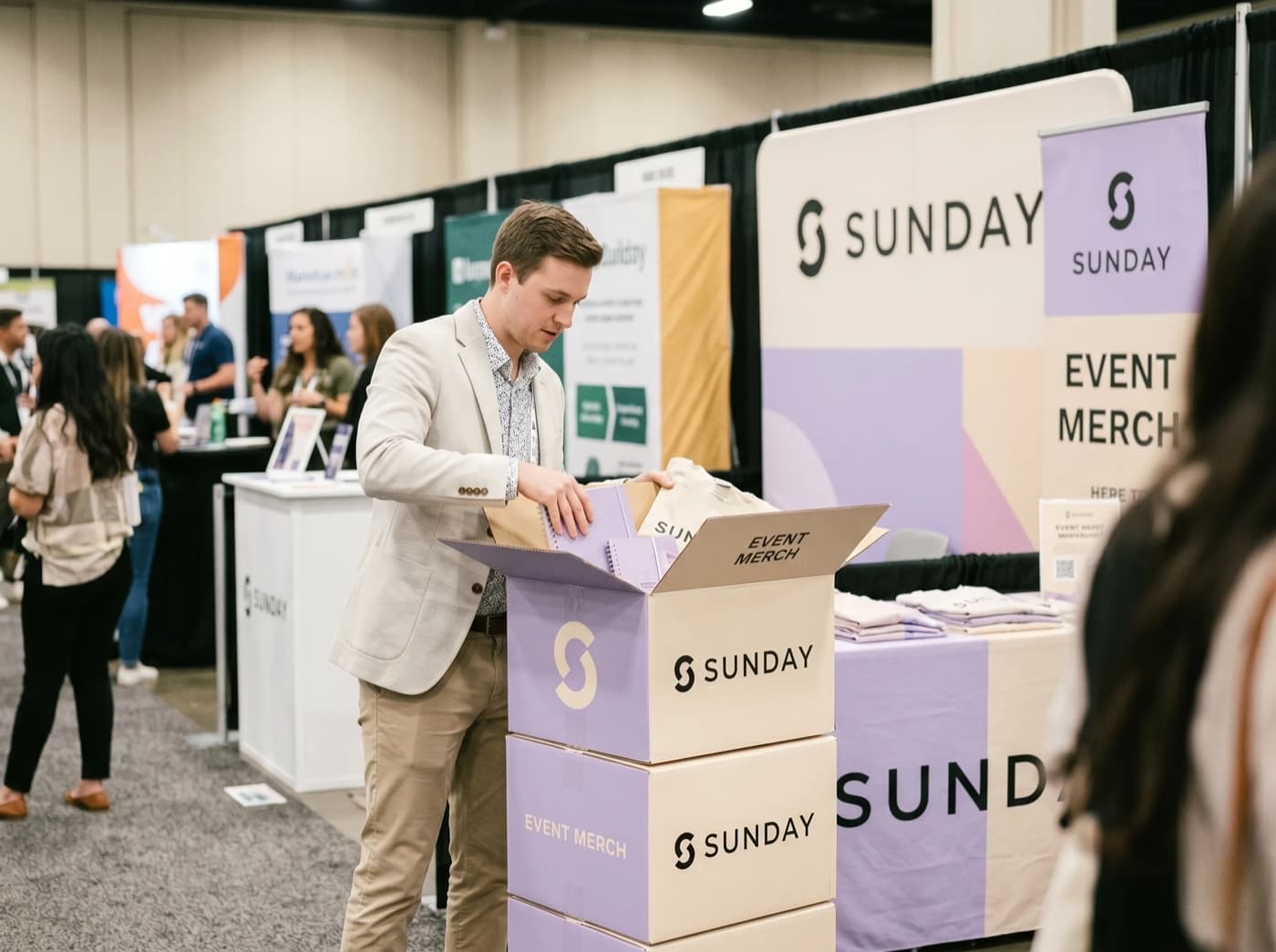 Branded event merch boxes delivered and unpacked at a trade-show venue