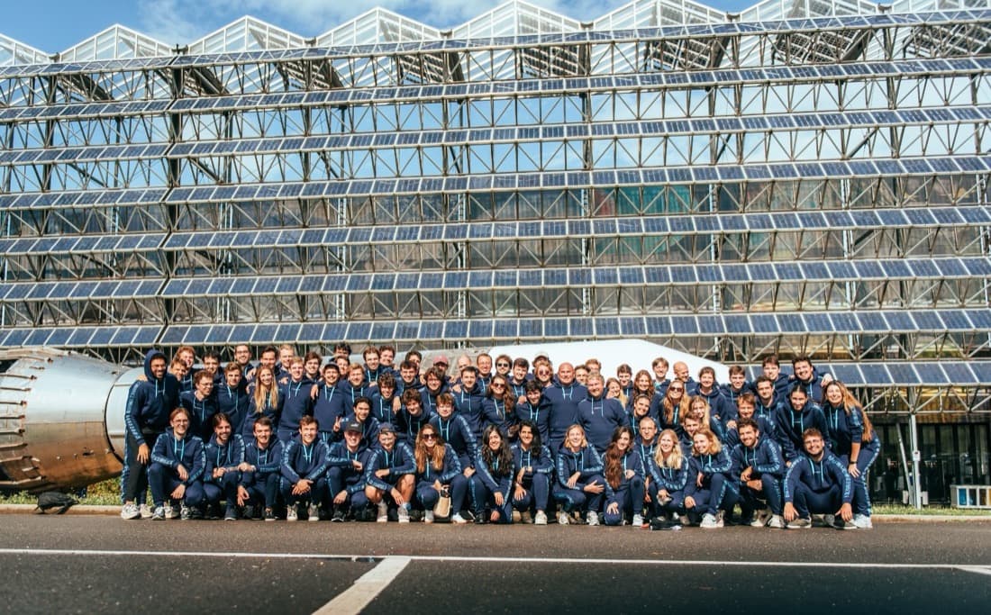 Techwolf team in matching navy jackets in front of a glass building
