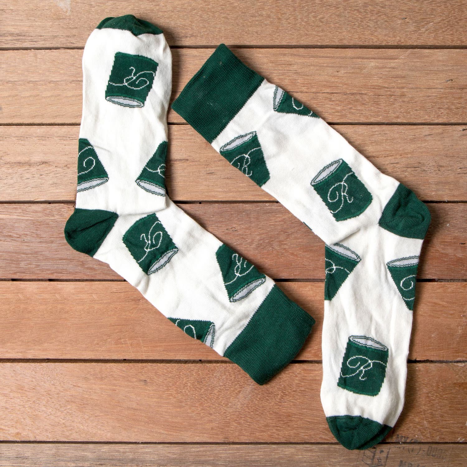 Branded custom socks with an all-over logo pattern laid flat on a wooden table