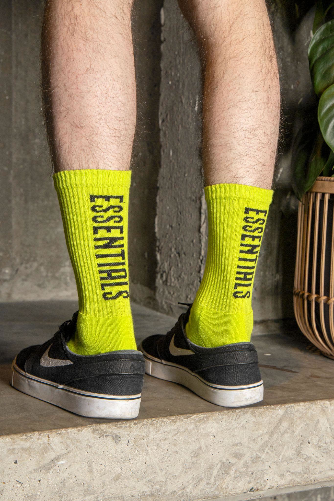 Person wearing bright branded crew socks with a vertical wordmark