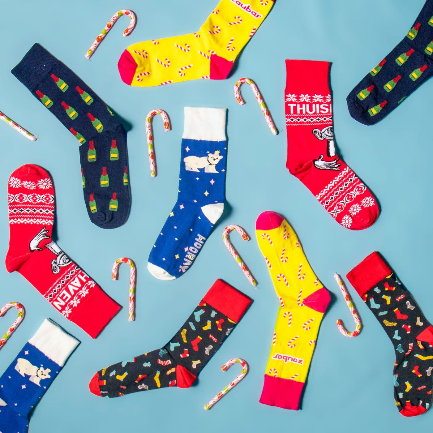 Calcetines de marca de colores dispuestos en plano con bastones de caramelo