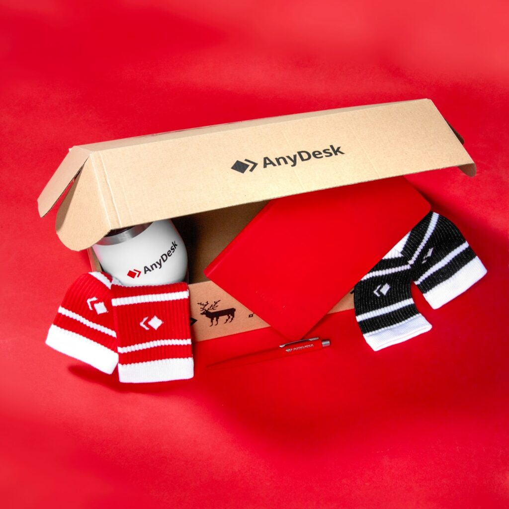 AnyDesk branded product mockups including sport t-shirt, tote bag, socks, lanyard, and backpack