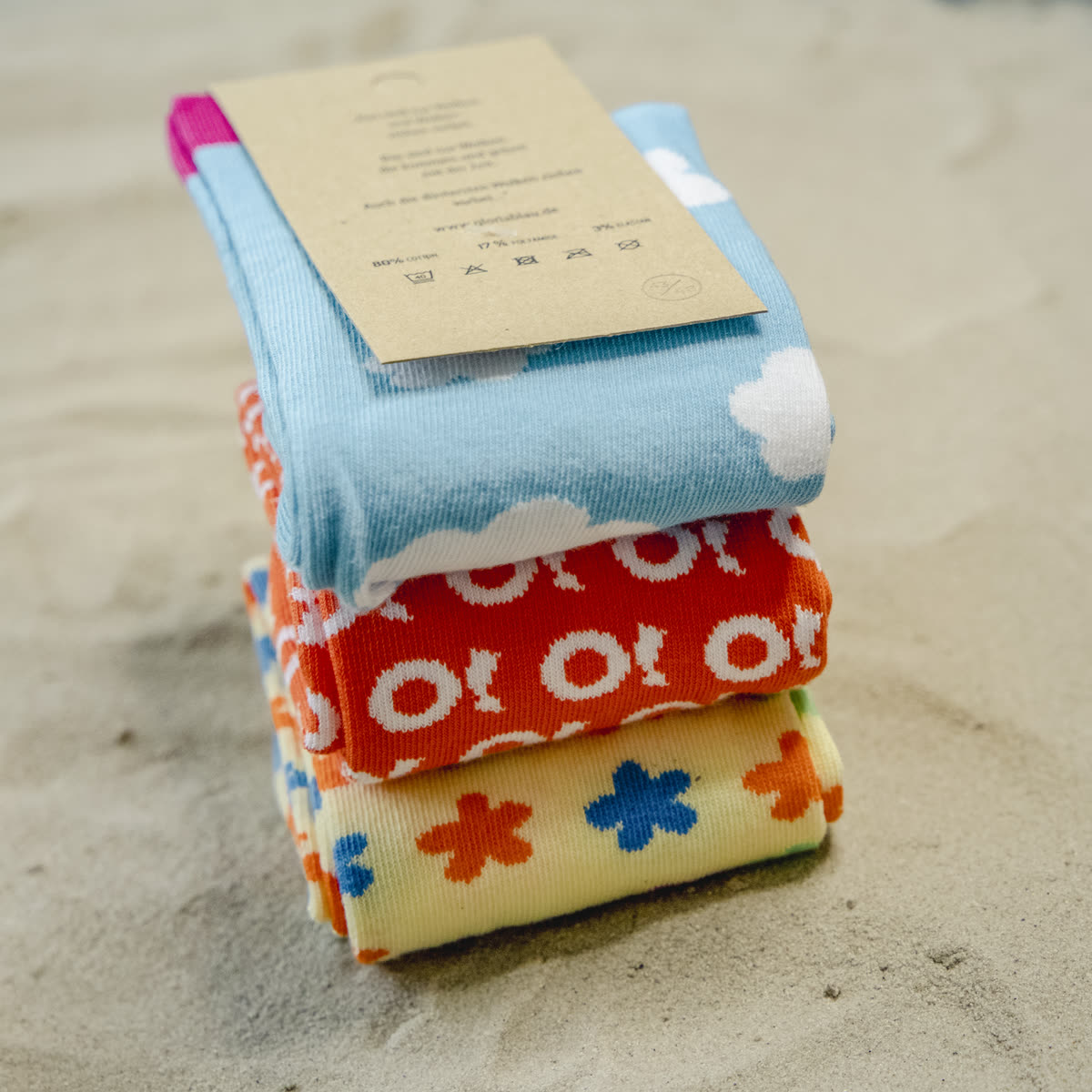 Stacked custom-knit socks with recycled cardboard branding, matching the sock mockup preview